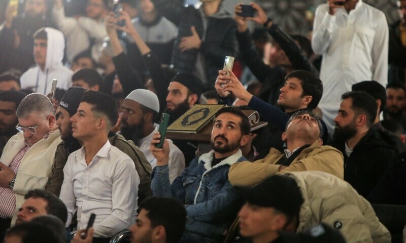  People take pictures after the morning prayer on the first day of Eidul Fitr, at the Umayyad Mosque in Damascus on March 31, 2025. — AFP 