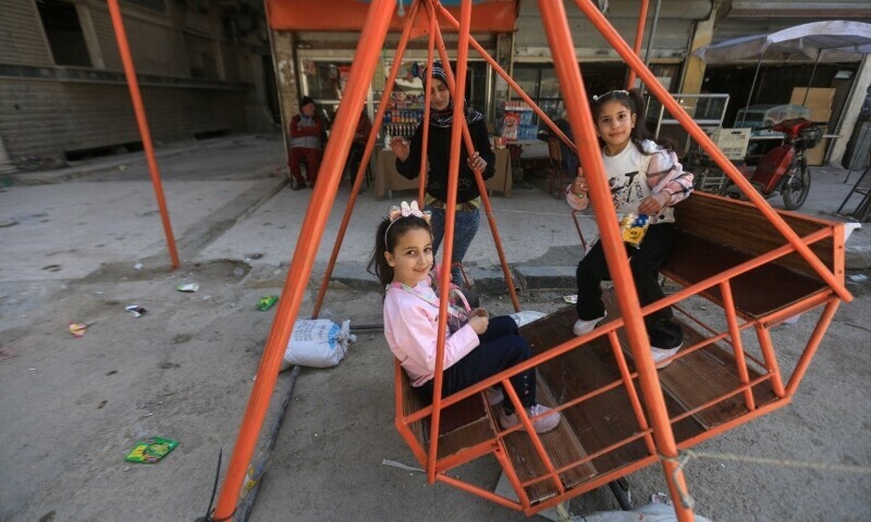  Children play in a swing as they celebrate the first day of Eidul Fitr, at the Yarmuk camp for Palestinian refugees in Damascus on March 31, 2025. — AFP 