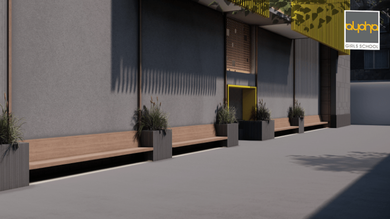 The entrance of Alpha Girls School features grey walls and  wooden benches.