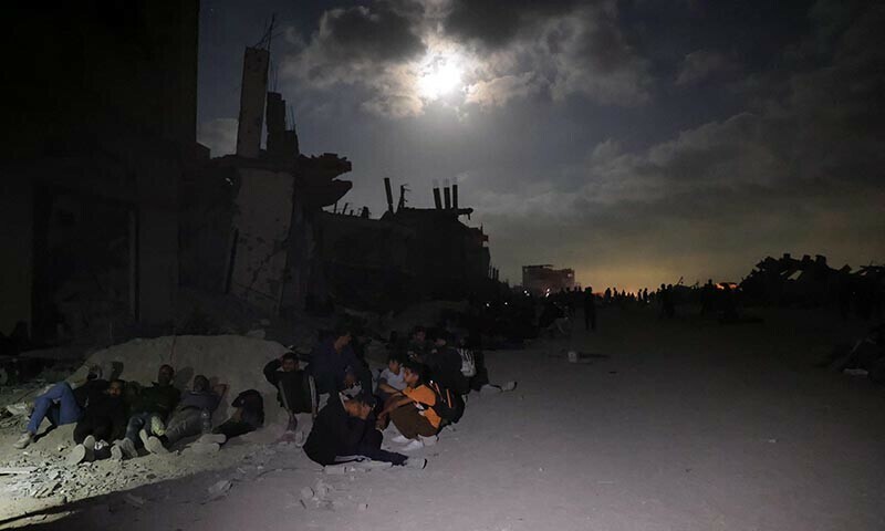 Palestinians gather in wait for the arrival of trucks carrying humanitarian aid near Jabalia, in the northern Gaza Strip late on June 15. &mdash; AFP