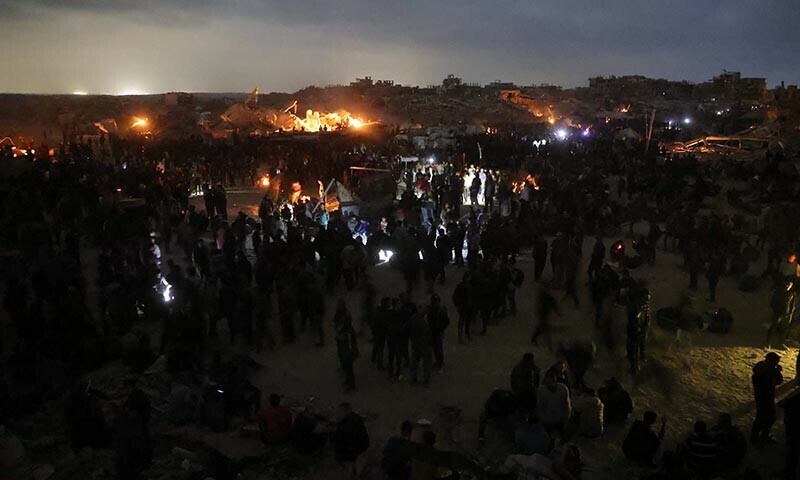 Palestinians gather in wait for the arrival of trucks carrying humanitarian aid near Jabalia, in the northern Gaza Strip late on June 15. &mdash; AFP