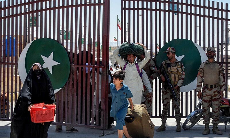Pakistani pilgrims evacuated from Iran walk across the Pakistan-Iran border at Taftan, in Balochistan on June 18 amid the ongoing conflict between Israel and Iran. — AFP
