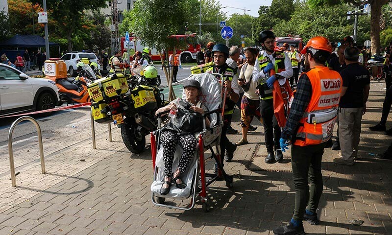 Israeli first responders evacuate an injured woman following an Iranian strike on a residential building in the Ramat Aviv area in Tel Aviv on June 22. &mdash; AFP