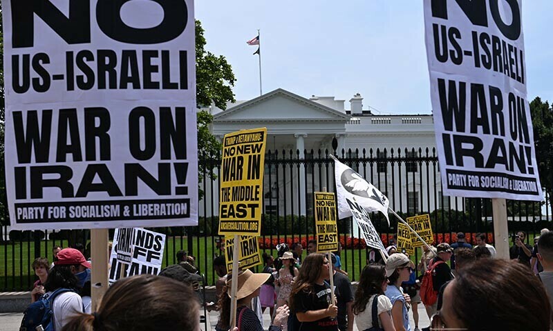 People hold signs as they demonstrate in front of the White House in Washington, DC, on June 22, 2025 against US strikes on Iranian nuclear sites. &mdash; AFP