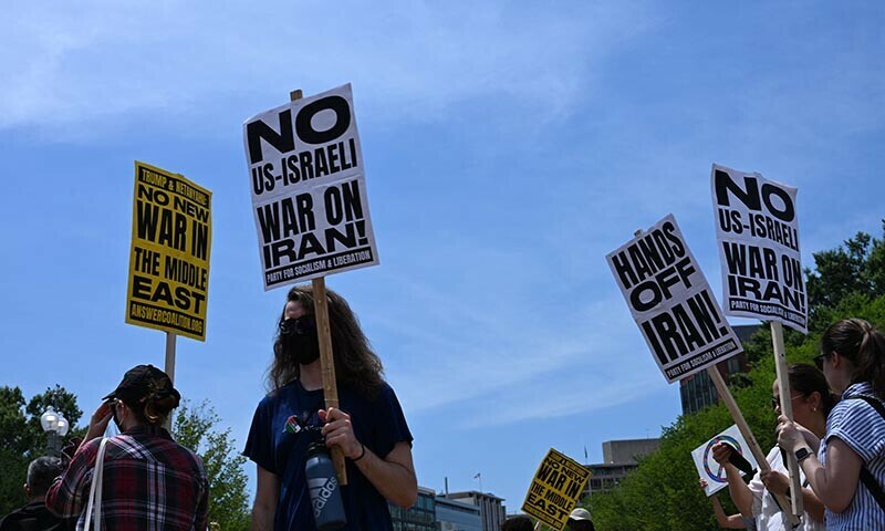 People hold signs as they demonstrate in front of the White House in Washington, DC, on June 22, 2025 against US strikes on Iranian nuclear sites. &mdash; AFP