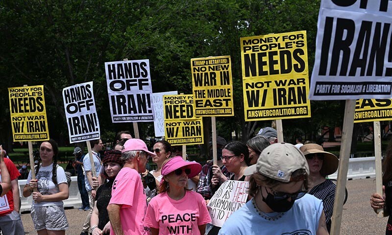People hold signs as they demonstrate in front of the White House in Washington, DC, on June 22, 2025 against US strikes on Iranian nuclear sites. &mdash; AFP
