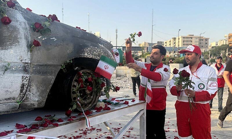 This handout picture provided by the Iranian Red Crescent on June 23, 2025 shows Iranian Red Crescent medics placing roses on an ambulance, that was targeted in an Israeli strike, as it displayed in Tehran. &mdash; AFP