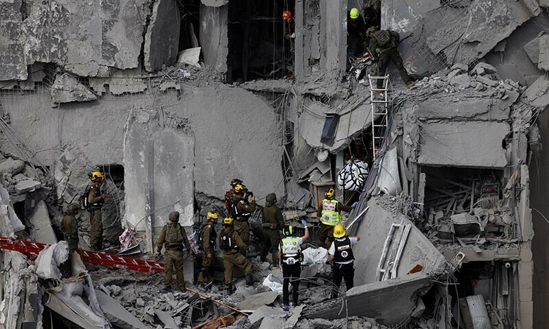 Emergency personnel work at an impacted residential site, following a missile attack from Iran on Israel, amid the Israel-Iran conflict, in Beersheba, Israel June 24. &mdash; Reuters
