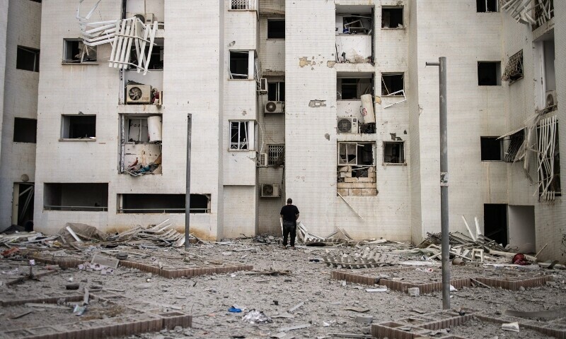 A man stands on debris beneath to a damaged building which was hit by an Iranian missile in Beersheba in southern Israel. &mdash; AFP