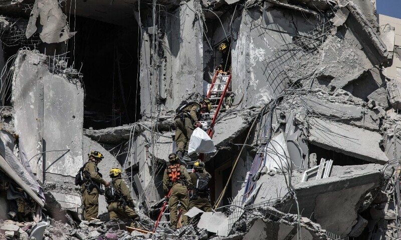 Israeli emergency services and security officers search for casualties in the rubble of a building hit by an Iranian missile in Beersheba in southern Israel. &mdash; AFP