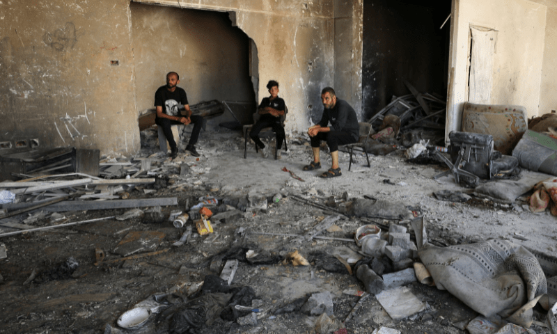  Palestinians sit as they inspect damage in the aftermath of an overnight Israeli strike on Al-Remal clinic where displaced people take shelter in Gaza City on July 7, 2025. &mdash; Reuters 