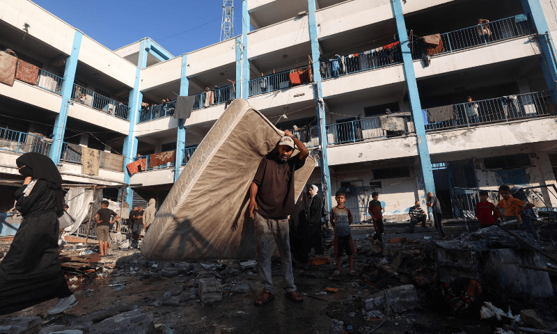  A Palestinian man carries a mattress after an Israeli strike which hit a school sheltering displaced Palestinians in the Al-Bureij camp in the central Gaza Strip on July 8, 2025. &mdash; AFP 