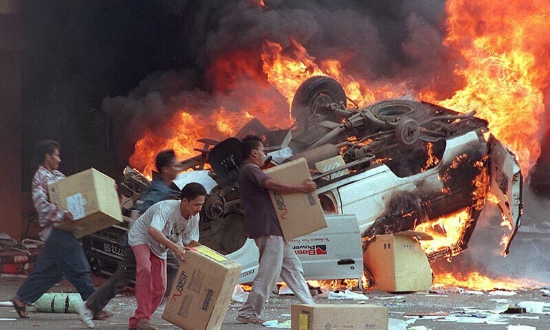Indonesian mobs burn cars and Chinese businesses as they plunder shops in Jakarta on May 14, 1998. — AFP/file