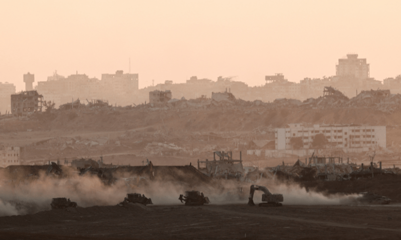  A tank drives near Israeli heavy machinery, as seen from the Israeli side of the Israel-Gaza border on July 13, 2025. — Reuters 