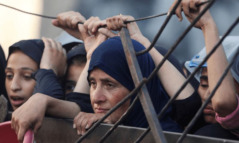  A Palestinian woman looks on as she waits to receive food from a charity kitchen, amid a hunger crisis, in Gaza City on July 14, 2025. &mdash; Reuters 