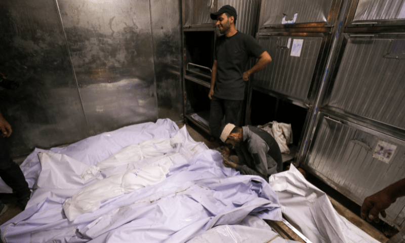  Hossam Azzam prays next to the body of his son Ameer, a Palestinian child killed in an overnight Israeli strike on a house, according to medics, and other bodies of victims at Al-Shifa hospital in Gaza City on July 15, 2025. — Reuters 
