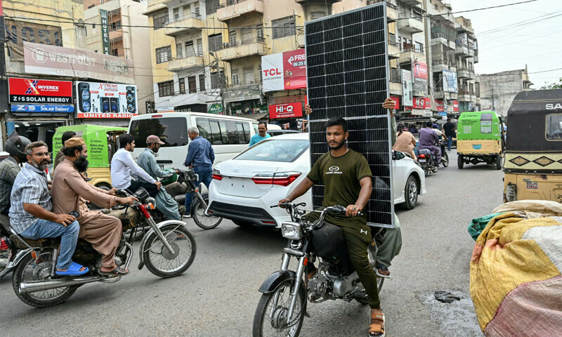 A local resident transports a solar panel on his motorcycle in Karachi, on June 23, 2025. — AFP