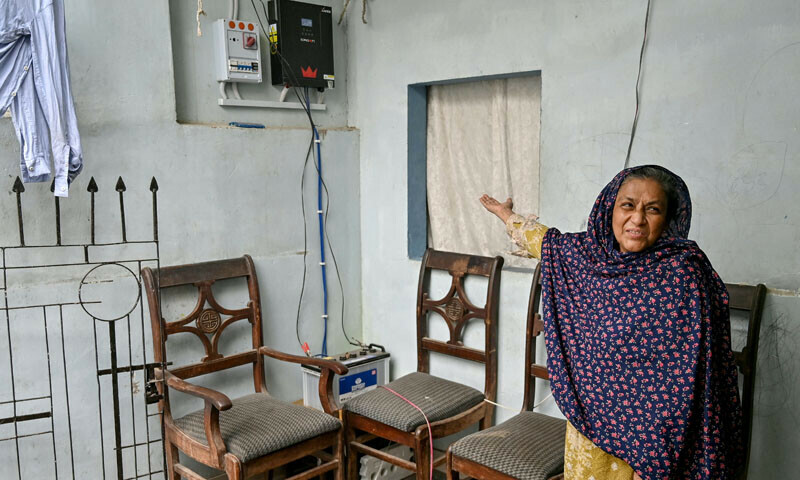 Fareeda Saleem, a local resident, shows a newly installed inverter at her home in Karachi, on June 24, 2025. — AFP