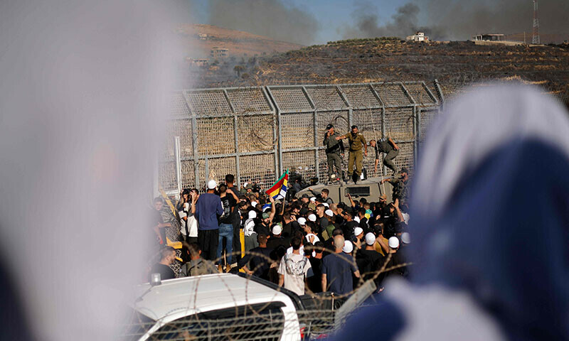 Members of the Druze community attempt to enter Syria through the buffer zone between Syria and the Israeli-annexed Golan Heights near Majdal Shams on July 16. — AFP