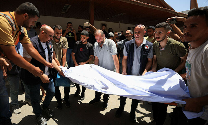 People carry the body of a Palestinian who was killed in an Israeli strike on the Church of the Holy Family in Gaza City on July 17, according to medics at Al-Ahli Arab Hospital. — Reuters