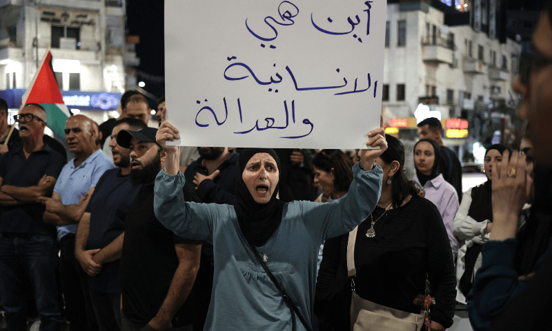  A Palestinian woman carries a placard during a demonstration in support of Palestinians in Gaza facing severe shortages of food and other essentials in the city of Ramallah in the Israeli-occupied West Bank on July 23, 2025. &mdash; AFP 
