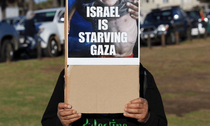  A pro-Palestinian activist holds a placard as they protest over hunger crisis in Gaza, along Sea Point Promenade in Cape Town, South Africa on July 27, 2025. &mdash; Reuters 