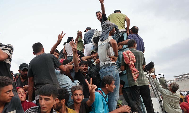 Palestinians climb in the back of a truck on a coastal path west of Beit Lahia after managing to get aid parcels on July 29, 2025, after aid trucks entered the Israel-besieged Gaza Strip from the northern Zikim border crossing. &mdash; AFP