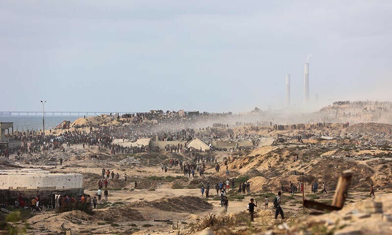 Palestinians gather on a coastal path west of Beit Lahia to attempt to get food aid on July 29, 2025, after aid trucks entered the Israel-besieged Gaza Strip from the northern Zikim border crossing. &mdash; AFP