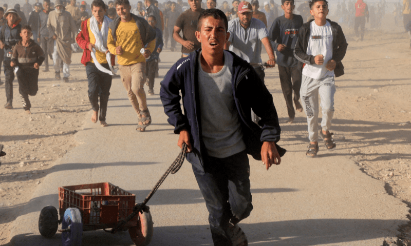  Palestinians walk to collect aid supplies from the U.S.-backed Gaza Humanitarian Foundation, in Khan Younis, in the southern Gaza Strip on May 29, 2025. &mdash; Reuters/File 