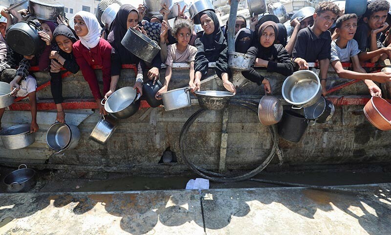 Palestinians wait to receive food from a charity kitchen, amid a hunger crisis, in Gaza City on August 2, 2025. — Reuters