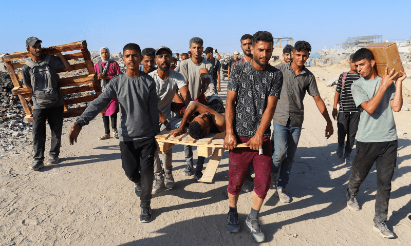 Palestinians carry a person wounded by Israeli fire, after aid supplies that entered Gaza through Israel arrived, in Beit Lahia, northern Gaza Strip on Aug 3, 2025. — Reuters/Ebrahim Hajjaj
