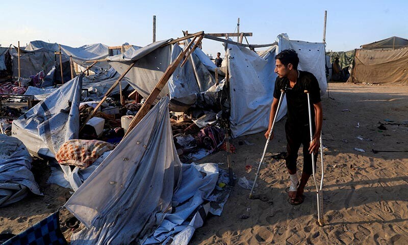 Palestinians inspect the damage at the site of an overnight Israeli strike on a tent sheltering displaced people, in Khan Younis, southern Gaza Strip on August 5, 2025. &mdash; Reuters