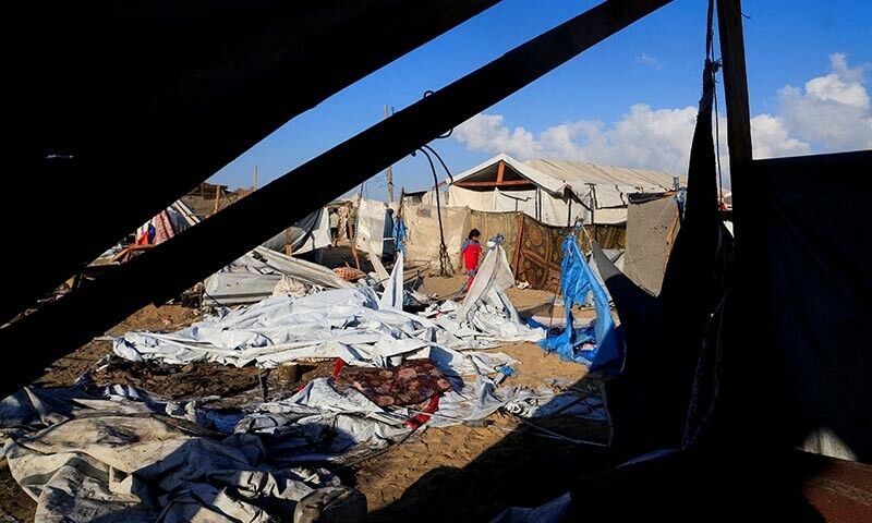 Palestinians inspect the damage at the site of an overnight Israeli strike on a tent sheltering displaced people, in Khan Younis, southern Gaza Strip on August 5, 2025. &mdash; Reuters