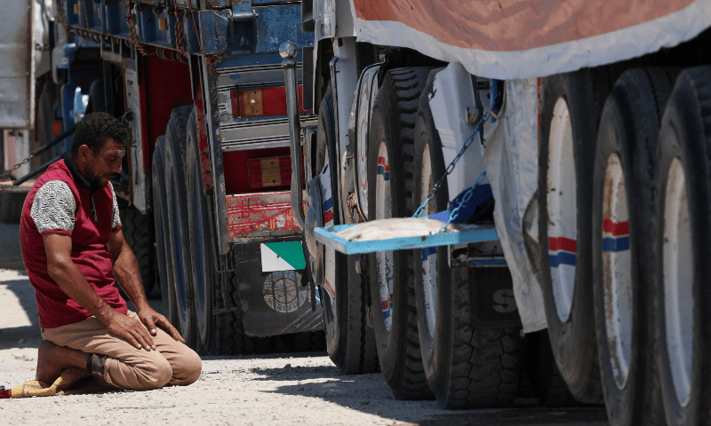 A truck driver prays as trucks carrying humanitarian aid line up near the Rafah border crossing between Egypt and the Gaza Strip, in Rafah, Egypt on Aug 6, 2025. — Reuters/Amr Abdallah Dalsh