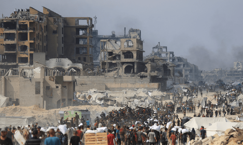  Palestinians carry aid supplies they collected from trucks that entered Gaza through Israel, in Beit Lahia, in the northern Gaza Strip on August 10, 2025. &mdash; Reuters 