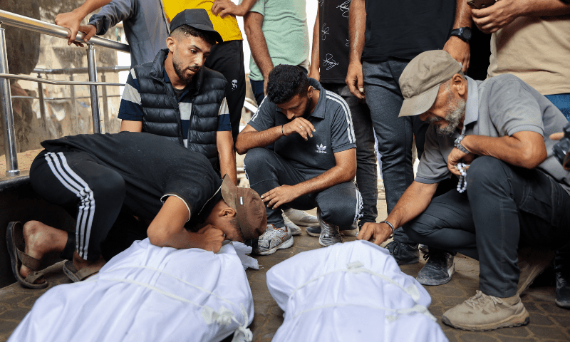  Palestinians mourn over the shrouded bodies of loved ones killed the previous day while seeking aid near Zikim, west of Beit Lahia, in the northern Gaza Strip, at Al-Shifa hospital in Gaza City on August 10, 2025. &mdash; AFP 