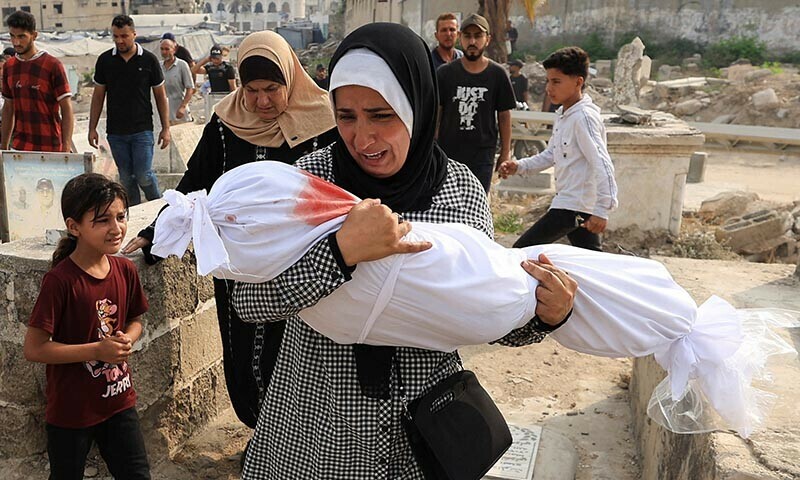 Palestinian woman Soha Tafesh carries the body of her granddaughter Sarah Abu Daf, who was killed in an early morning Israeli strike on a house, according to medics, at a cemetry in Gaza City, August 13, 2025. — Reuters