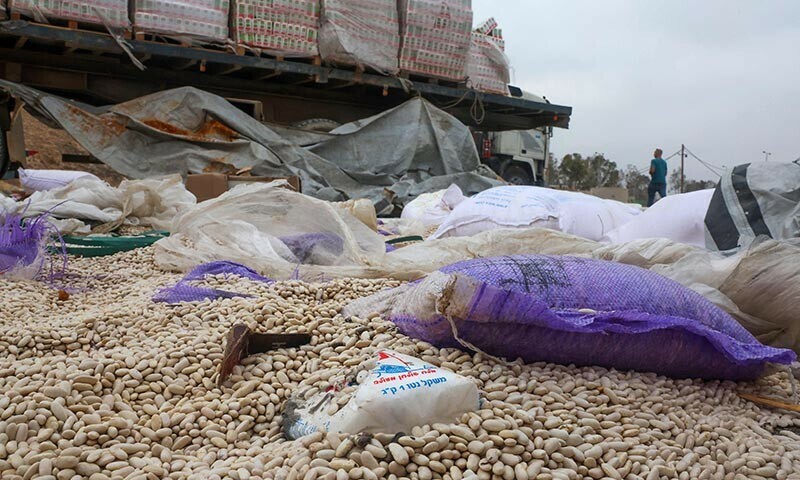 Damaged humanitarian aid for Palestinians in Gaza lies scattered on the ground next to broken-down trucks near the border with the Gaza Strip, close to the Kissufim crossing in southern Israel, on August 13, 2025. &mdash; AFP