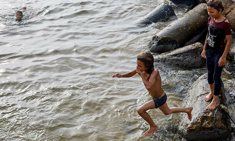 A displaced Palestinian child  jumps into the sea to cool off during summer heat in Gaza City, August 12, 2025. &mdash; Reuters