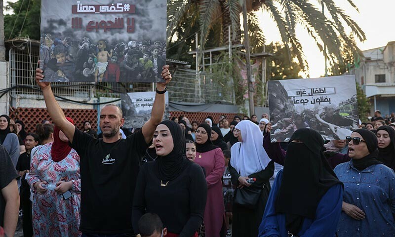Israeli Arabs hold placards and chant slogans on August 16, 2025, as they protest in the city of Lod near Tel Aviv, to denounce food shortages in the Gaza Strip and the ongoing war on the Palestinian territory. &mdash; AFP