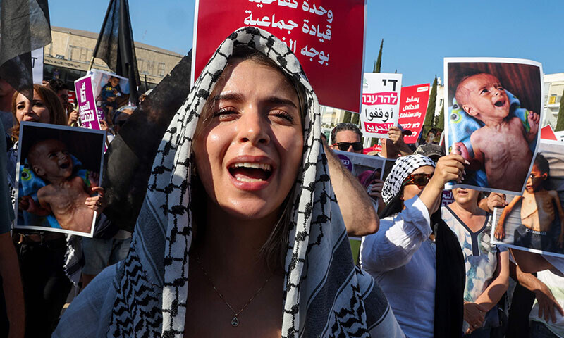 Arab-Israelis and Israeli left-wing activists hold placards and chant slogans during a protest at Habima square in Tel Aviv, Israel on August 23, against the ongoing conflict and catastrophic humanitarian situation in the Gaza Strip. &mdash; AFP