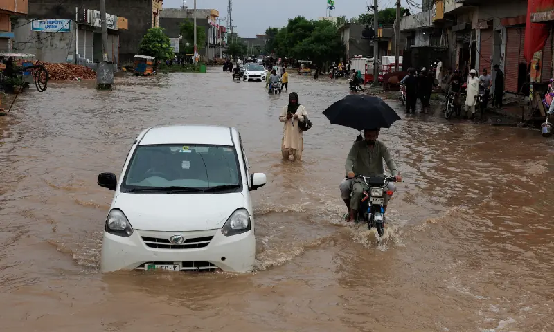 Vehicles move along a flooded street following monsoon rains and rising water levels in Punjab’s Sialkot, on August 27. — Reuters