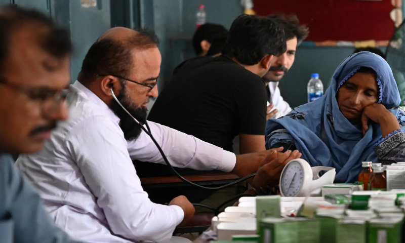  A doctor checks an evacuated resident from her submerged home, as she takes shelter at a government school after floodwaters entered from the overflowing Ravi river in Shahdara, Lahore on August 29, 2025. &mdash; AFP 