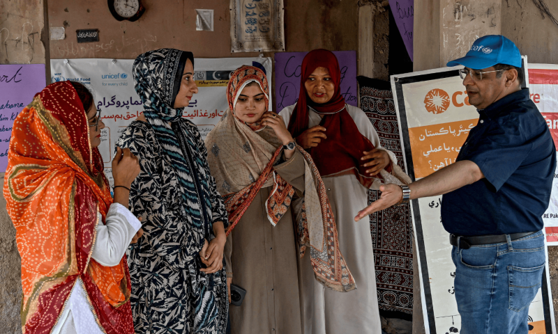 This photograph taken on July 29, 2025 shows Mazhar Iqbal (R), a UNICEF nutritionist, instructing female health workers during a UNICEF nutrition programme at Fateh Muhammad Soomro village in the Sujawal district of Sindh. — AFP