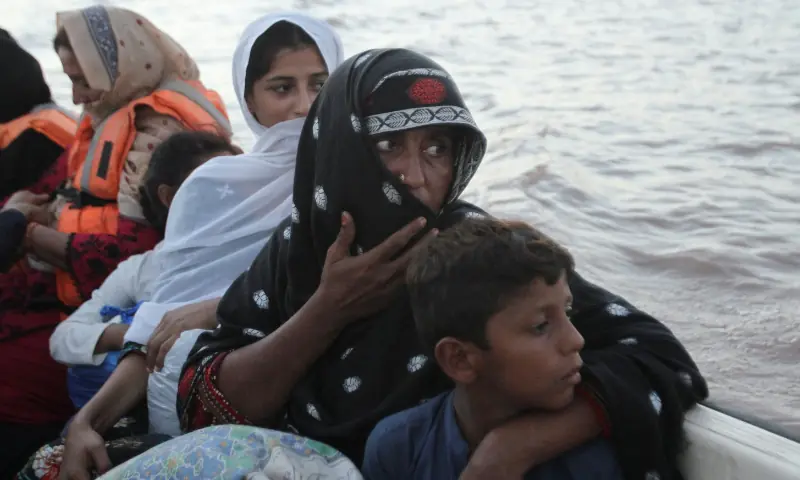 Tasneem Bibi sits with her children in a rescue boat as they evacuate following monsoon rains and rising water levels in the Chenab river, in Punjab&rsquo;s Basti Khan Bela, on the outskirts of Jalalpur Pirwala, on September 10, 2025. &mdash; Reuters