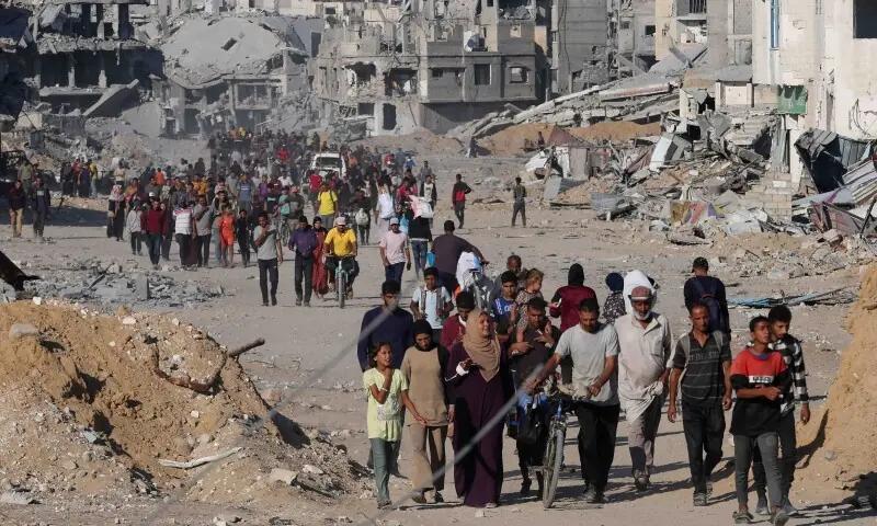 Palestinians walk past rubble as they return to their neighborhood, following Israeli forces&rsquo; withdrawal from the area, amid a ceasefire between Israel and Hamas in Gaza, in Khan Younis, in the southern Gaza Strip on October 11. &mdash; Reuters