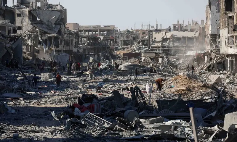Palestinians walk among rubble following Israeli forces&rsquo; withdrawal from the area, amid a ceasefire between Israel and Hamas in Gaza, in Khan Younis, in the southern Gaza Strip on October 11. &mdash; Reuters