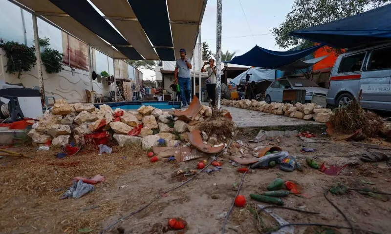 Palestinians inspect the site of an Israeli airstrike that targeted a residential compound housing employees of the Palestine Media Production Company in Zawaida in the central Gaza Strip on October 19. &mdash; Reuters