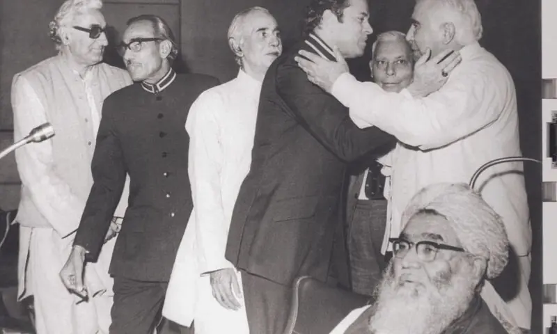   اپریل 1973ء میں آئین کی توثیق کے بعد چاروں طرف مسکراہٹیں۔ بائیں طرف سے نظر آنے والے خان عبدالولی خان، شیخ رحید، سردار شوکت حیات، عبدالحفیظ پیرزادہ اور میر غوث بخش بزنجو (انتہائی دائیں) جبکہ مفتی محمود صاحب بیٹھے ہوئے ہیں—تصویر: قومی اسمبلی آرکائیوز  