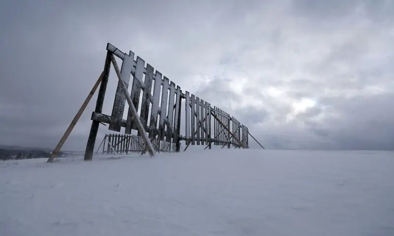 A fence stands in the snow-covered landscape in Oy Mittelberg, Germany on November 20. — AFP